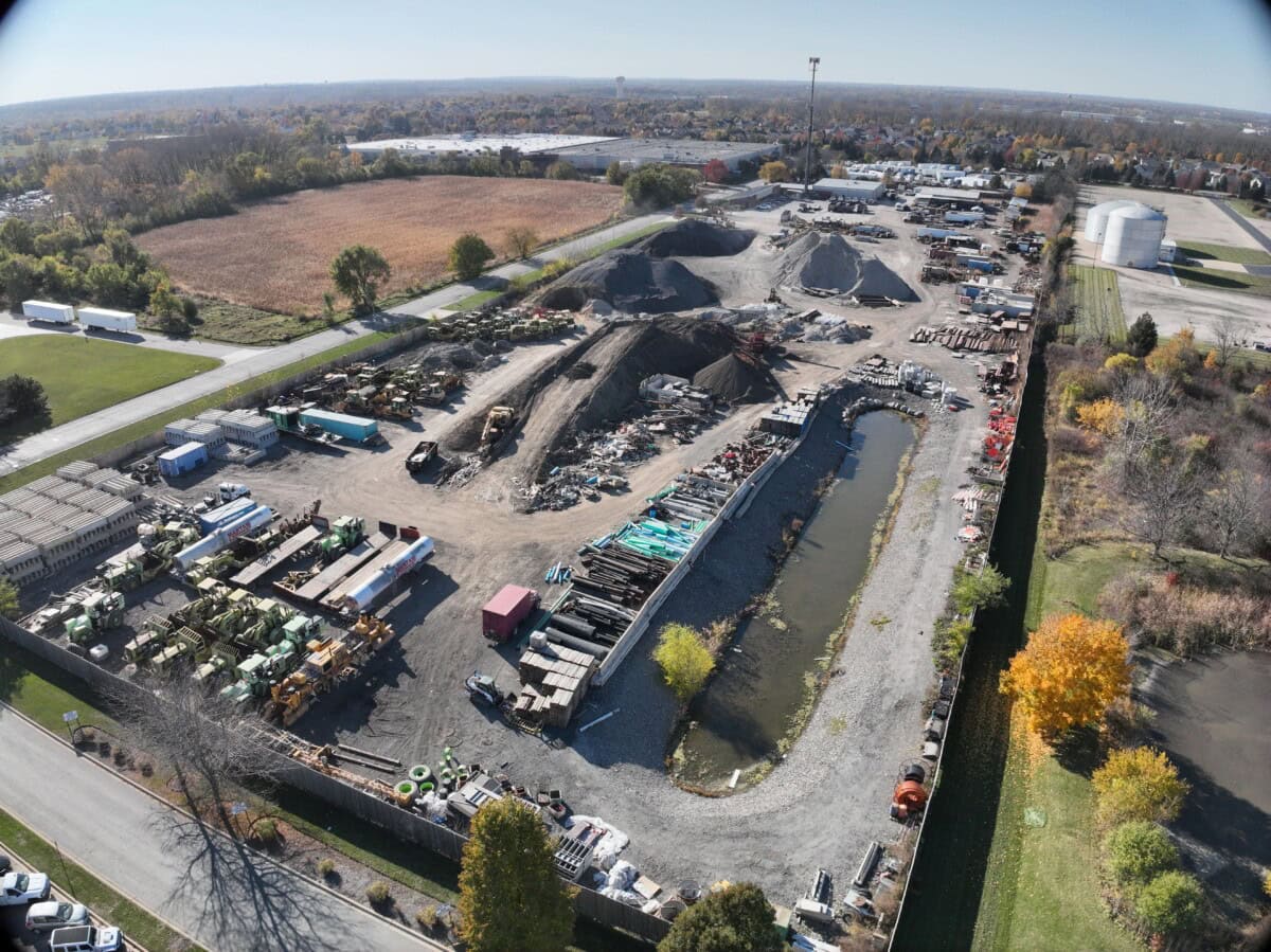 Construction site with heavy machinery, materials, and ongoing development work.